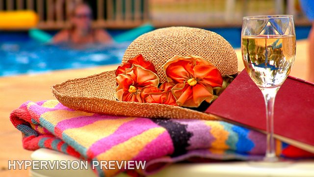 Sun Hat and Wine Glass Beside a Pool