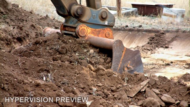 Excavator Bucket Digging into Soil