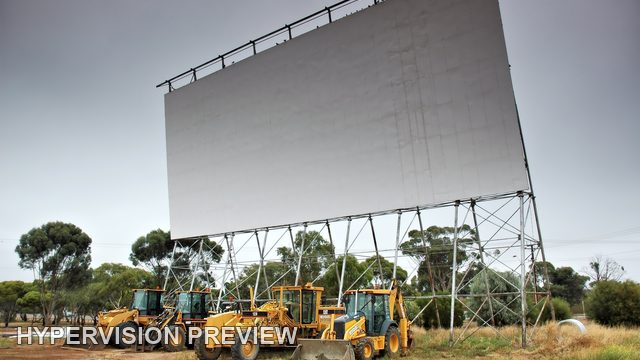 Drive-In Cinema Screen Above Parked Machinery