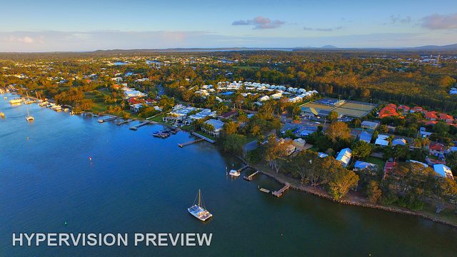 Waterfront Homes and Sailboat at Dusk
