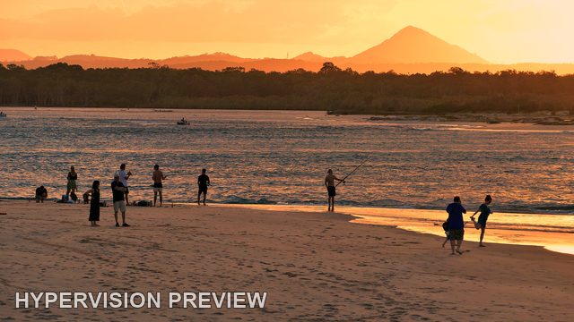 People on the Shore Beneath a Golden Sunset