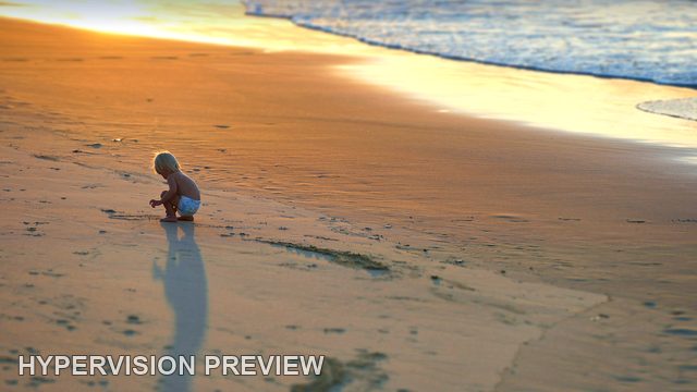 Child Playing on Wet Sand in Golden Light