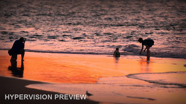 People and Child Paddling at Sunset