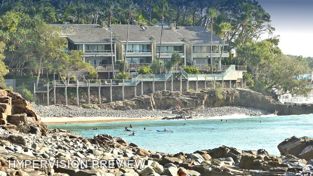 Waterfront Buildings Above a Rocky Surf Cove — Colour
