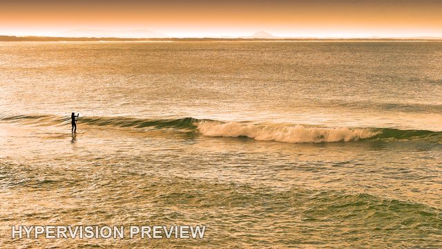 Paddleboarder Beside a Long Breaking Wave — Warm Colour