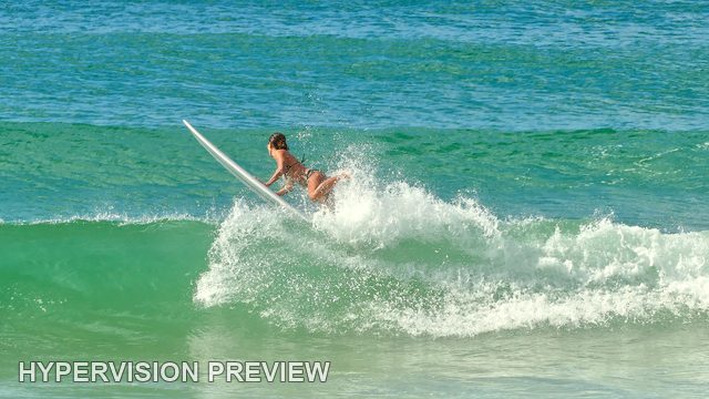 Surfer and Raised Board Above a Wave — Colour