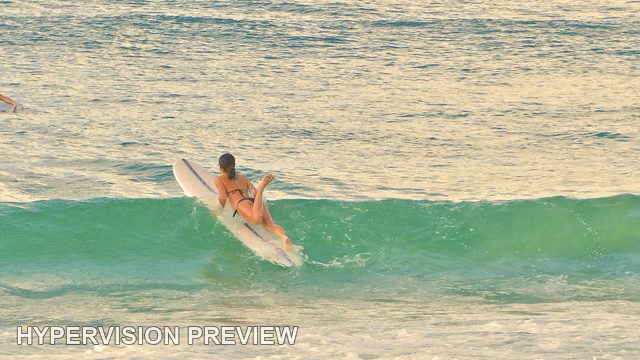 Surfer Paddling Over a Green Wave — Colour