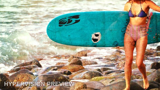 Turquoise Surfboard Beside Shoreline Rocks — Warm Textured Colour