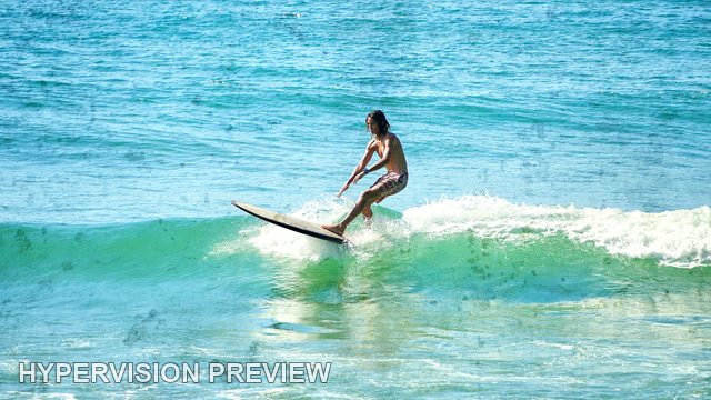 Longboard Rider Gliding Across a Green Wave — Fine Textured Colour