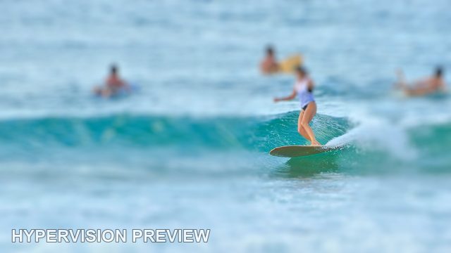 Longboarder with Surfers Waiting Beyond — Selective Focus 02