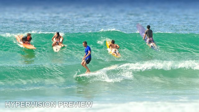 Surfer Riding Past a Busy Lineup — Colour