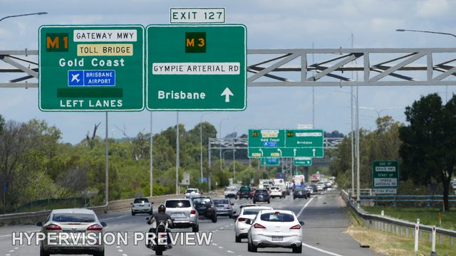 Motorcyclist Approaching a Motorway Sign Gantry