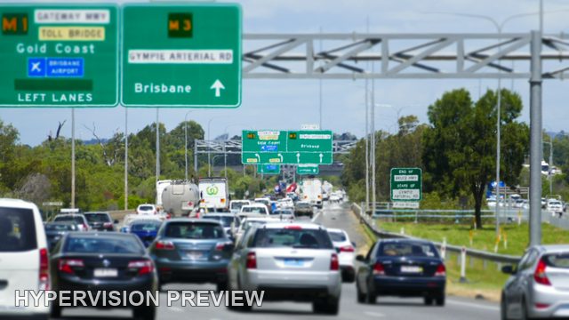 Closely Spaced Cars Approaching Motorway Exit Signs