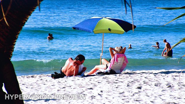 Beach Umbrella and Swimmers Beneath Coastal Shade