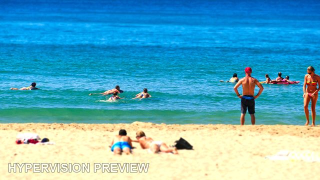 Swimmers Beyond Sunbathers on Golden Sand