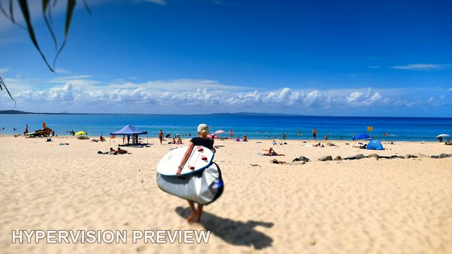 Surfer Carrying a Board Toward the Beach