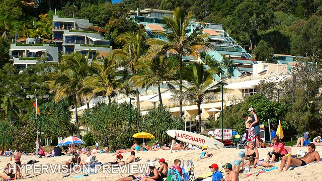 Beachgoers Below Palms and Hillside Apartments