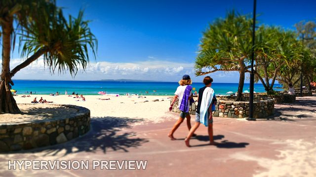 Two Walkers on a Sunny Beachfront Promenade