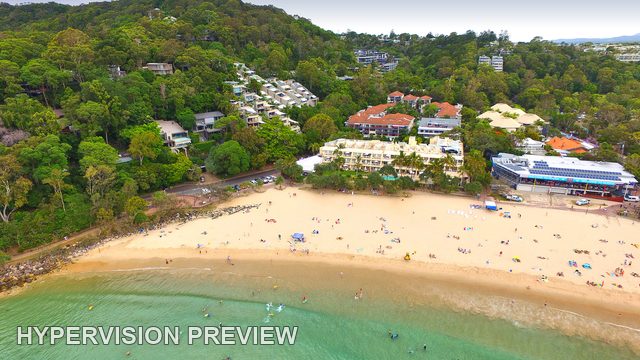 Sheltered Beach Beneath Trees and Apartments