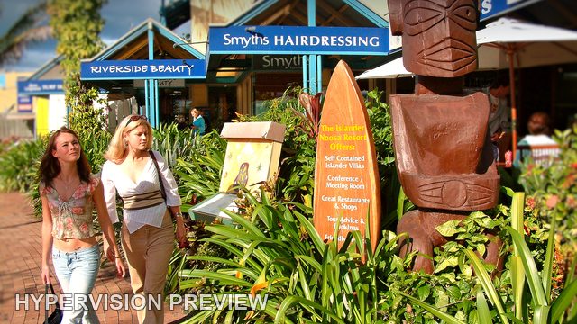 Pedestrians Passing Noosa Shops and a Carved Figure