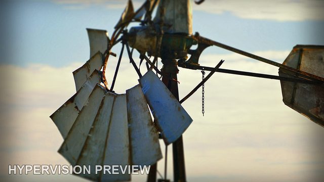 Weathered Windmill Blades Against a Soft Blue Sky