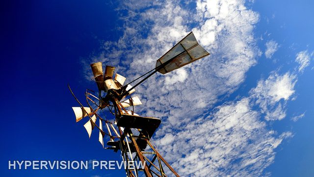 Windmill Rotor and Tail Beneath Sweeping White Clouds
