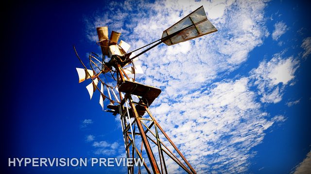 Weathered Windmill Tower Against Brilliant Blue Sky