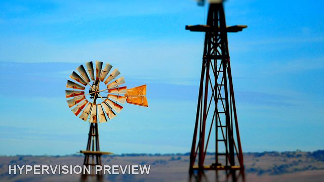 Distant Windmill Beside a Tall Foreground Tower