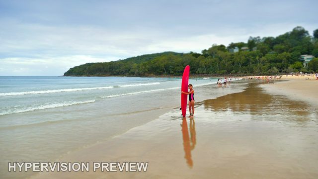 Young Surfer with an Upright Red Board at the Shore