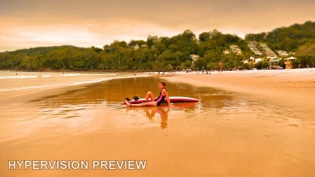 Young Surfer Reflected in Wide Beach Shallows — Warm Edit