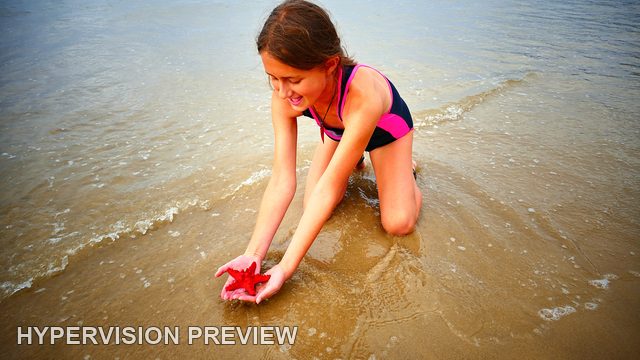 Child Examining a Red Starfish-Shaped Object