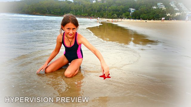 Child Kneeling with a Red Object Beside the Water — White Vignette Edit