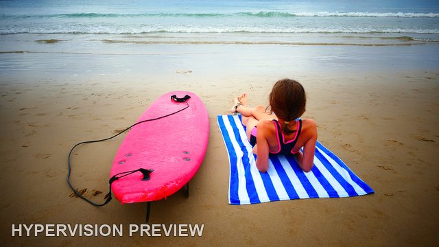 Young Surfer Relaxing on a Striped Beach Towel