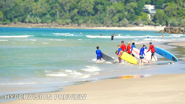 Group Carrying Surfboards into the Shallows