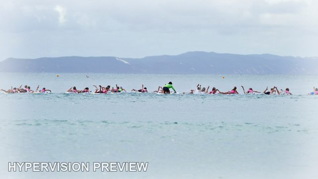 Distant Line of Board Riders on Calm Water